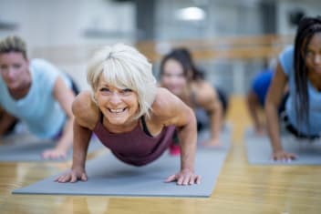 a woman smiling participating in a yoga class