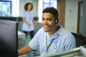 a smiling man wearing a telephone headset.