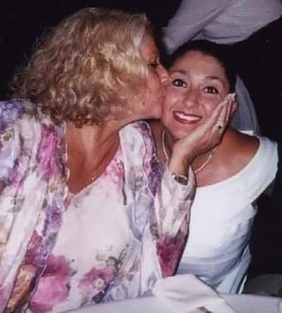 bride being kissed on her cheek by her mother
