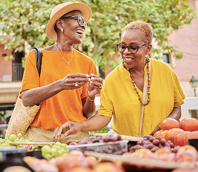 two women enjoying a buffet of healthy foods to lower blood pressure