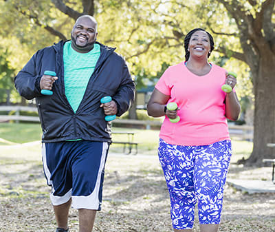 couple power walking with weights to lower blood pressure