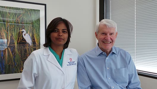 photo of patient Joe Cawley and Ruby Satpathy, MD, interventional cardiologist, sitting in an office