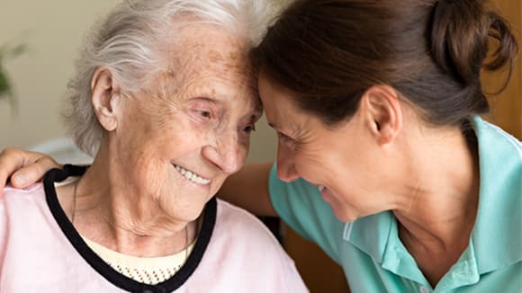 an elderly woman being embraced by a younger woman