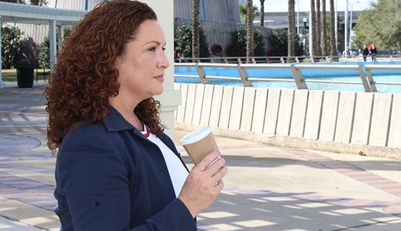 Patient Hope Tallon stands outside drinking a cup of coffee