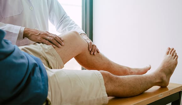doctor with his hands on a male patient's knee