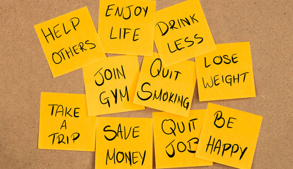 Sticky notes with resolutions: "Lose weight," "Help others," "Quit Smoking."