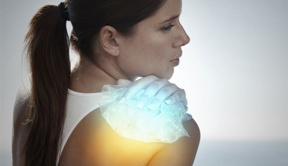woman applying ice and heat to shoulder