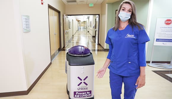 Nurse standing next to cleaning robot
