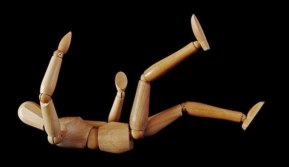 A wooden artist's figure falling backwards