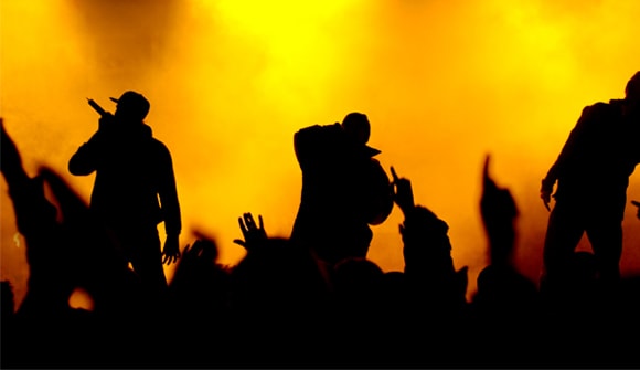 silhouetted image of crowd and musicians on stage