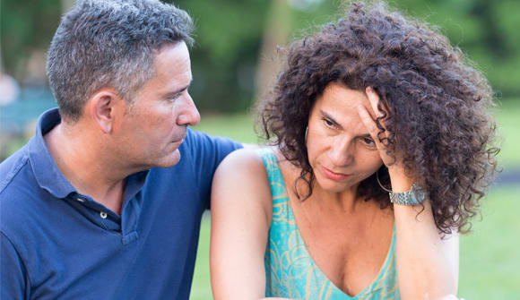 A frustrated woman is comforted by her male partner