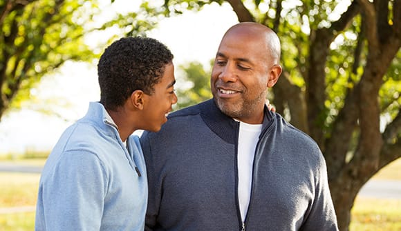 A father and son talking and smiling