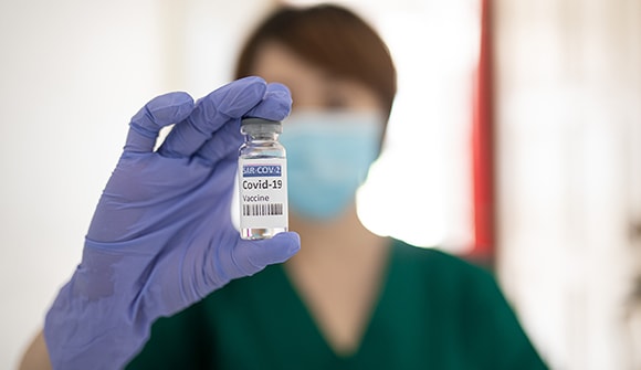 Nurse holding vaccine vial