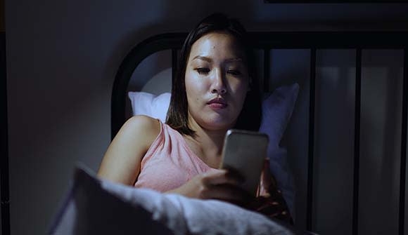woman looking at her phone screen in the dark