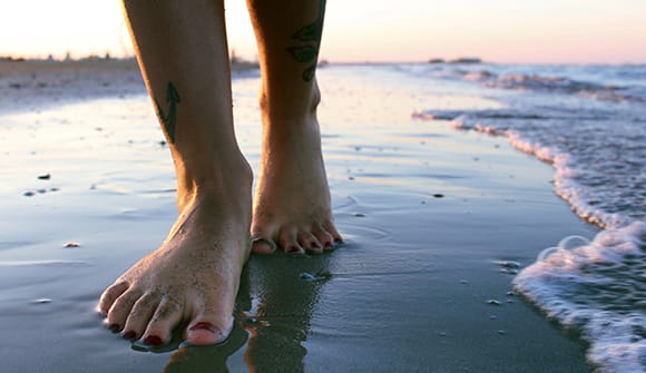 Barefoot walking in the surf at dawn
