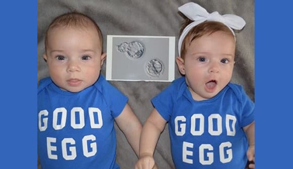 Sara Walsh's boy/girl twins wearing onesies that say "Good egg" with a photo showing microscopic embryos.