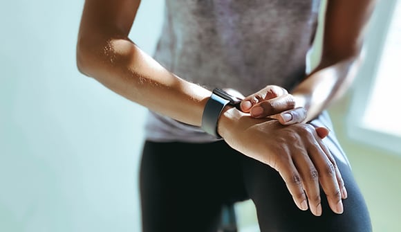 a close up photo of a man tapping his smart watch on his wrist.