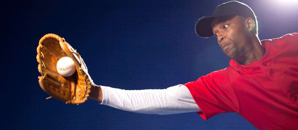 a baseball player catching a ball in his mitt.