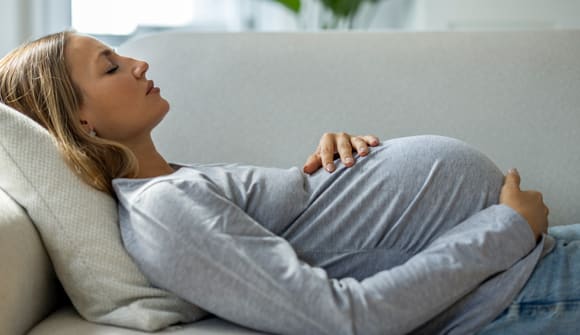 A pregnant woman lying on a couch