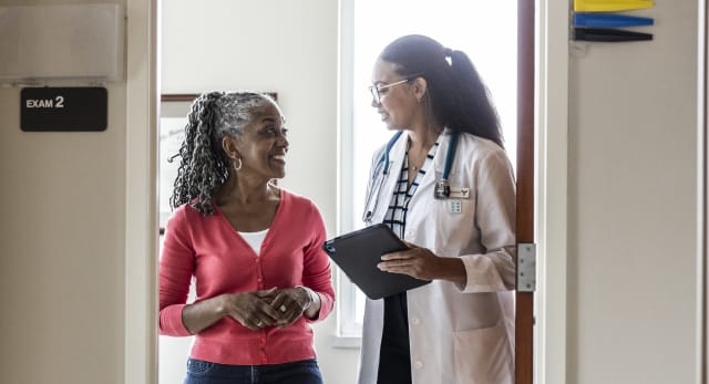 a female doctor talking to a female patient who is smiling