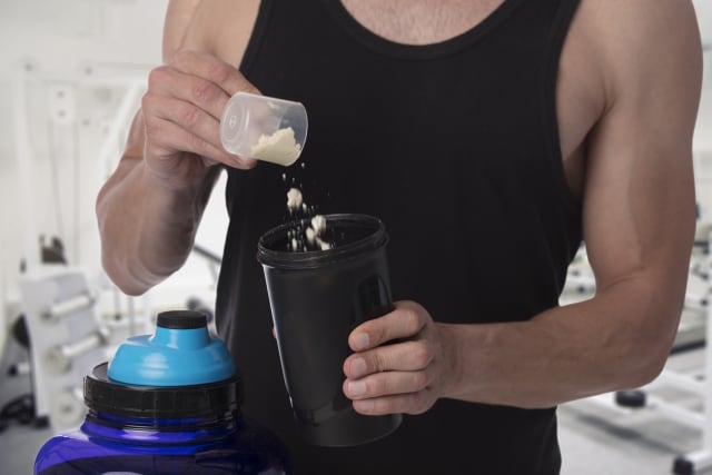Person pouring creatine into a bottle