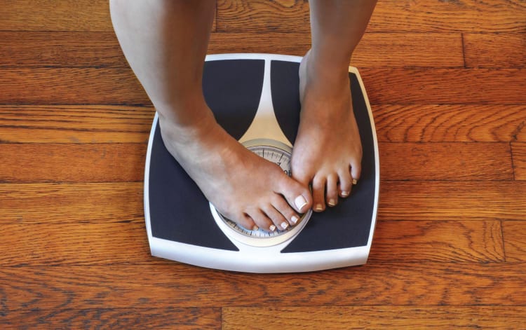 feet on a scale depicting weight loss