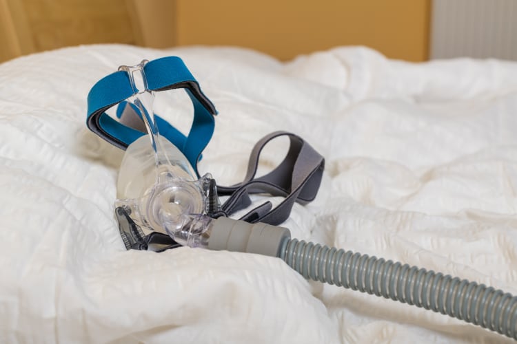cpap mouthpiece and head strap with tubing on a pillow