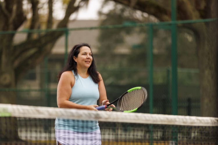 a healthy woman plays tennis after finding a long-term weight loss solution -- bariatric surgery