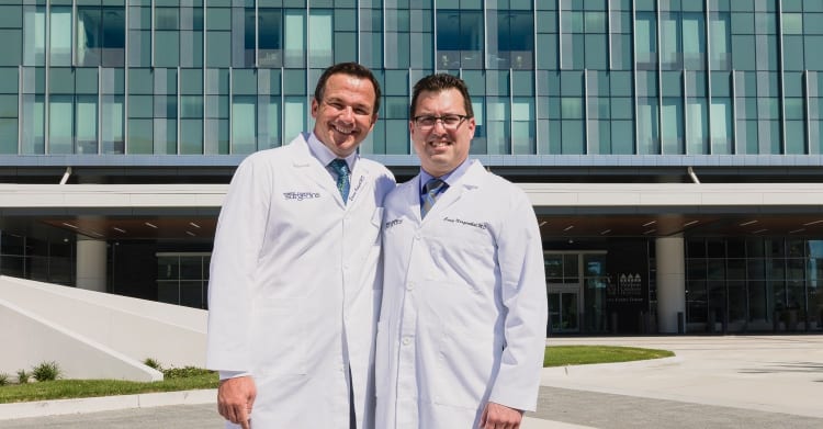 two bariatric doctors standing in front of a hospital