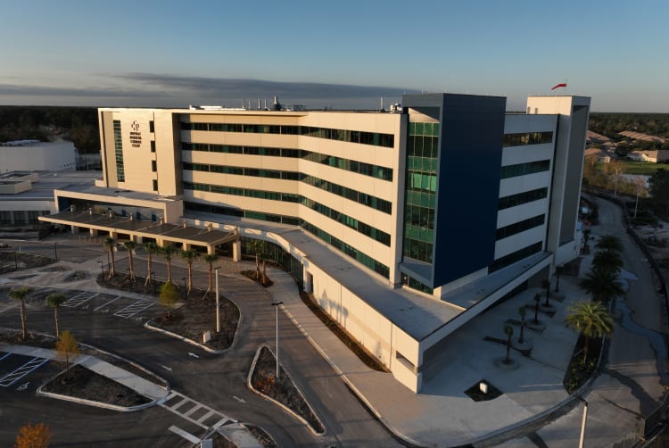 aerial photograph of the Baptist Medical Center Clay building with morning light shining on the front of building and blue skies behind.