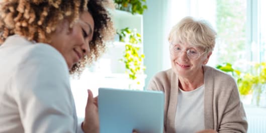 Smiling senior woman talking with healthy living coach.