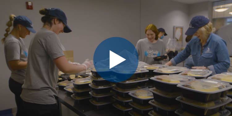 group of 4 female volunteers packaging meals in takeout containers
