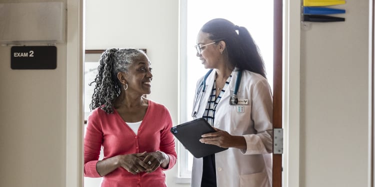 a female doctor talking to a female patient who is smiling