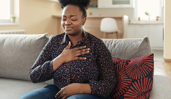 A woman clutching her chest like she is having heart palpitations