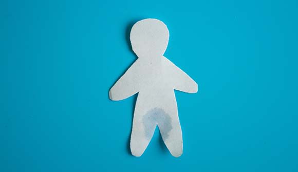 Paper cutout of a man that's wet around the crotch