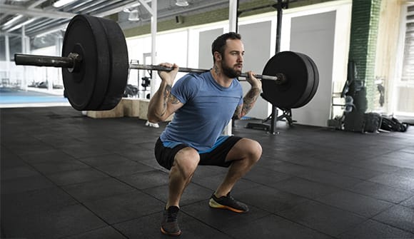 A man uses proper lifting techniques to avoid injury