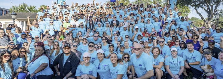 a very large group of baptist employees all wearing the same t-shirt at a community event