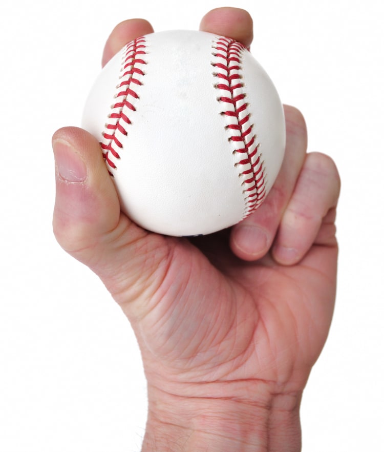 photograph of hand holding a white baseball with red stitching