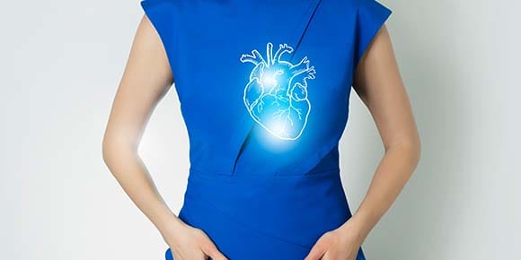 The torso of a white woman in a blue dress is shown with a graphic image of an anatomical heart on her chest