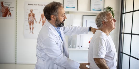 doctor examining a man's spine