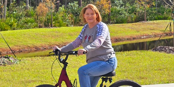 woman on a bike beside the sidewalk outside