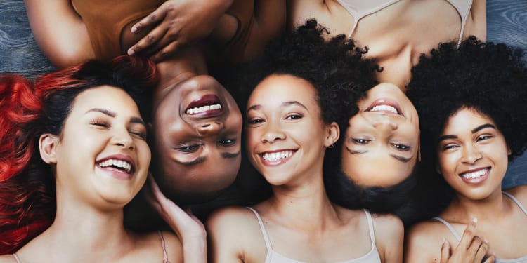 a group of young women with different colored skin tones smiling