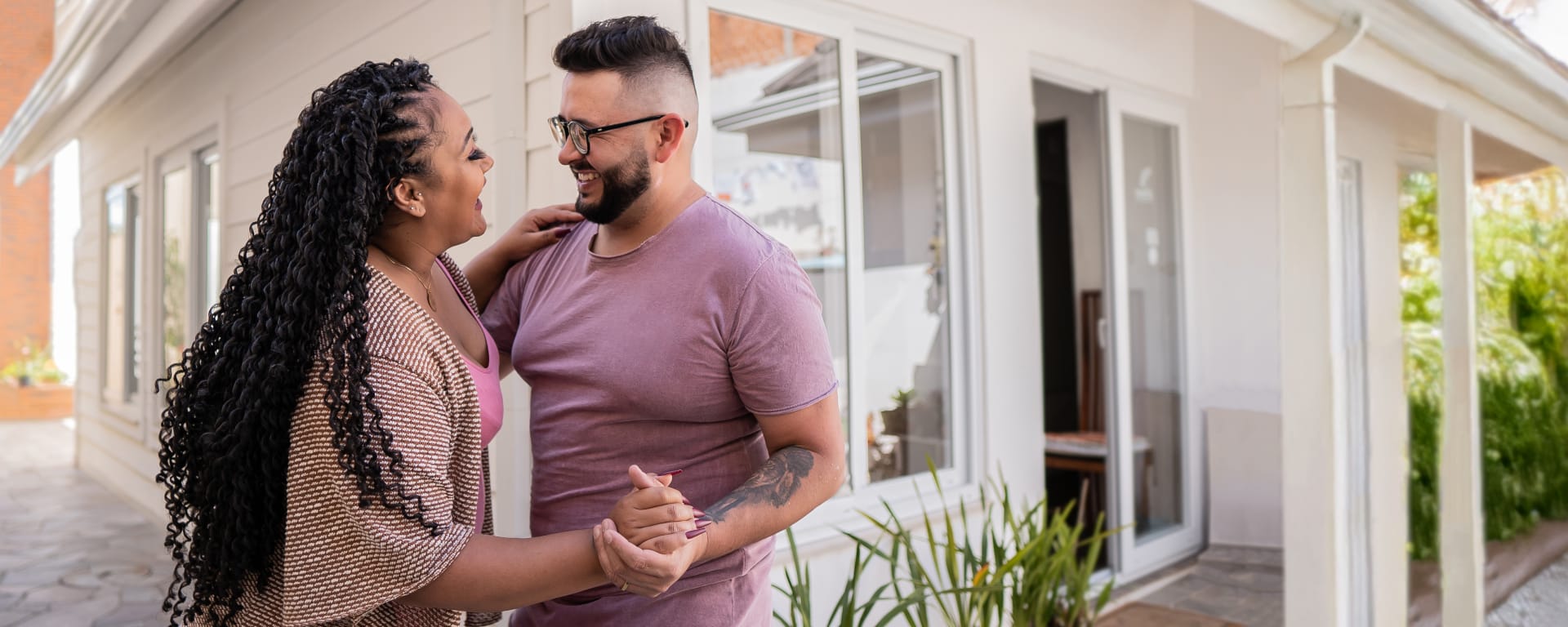 smiling couple dancing in front of their home