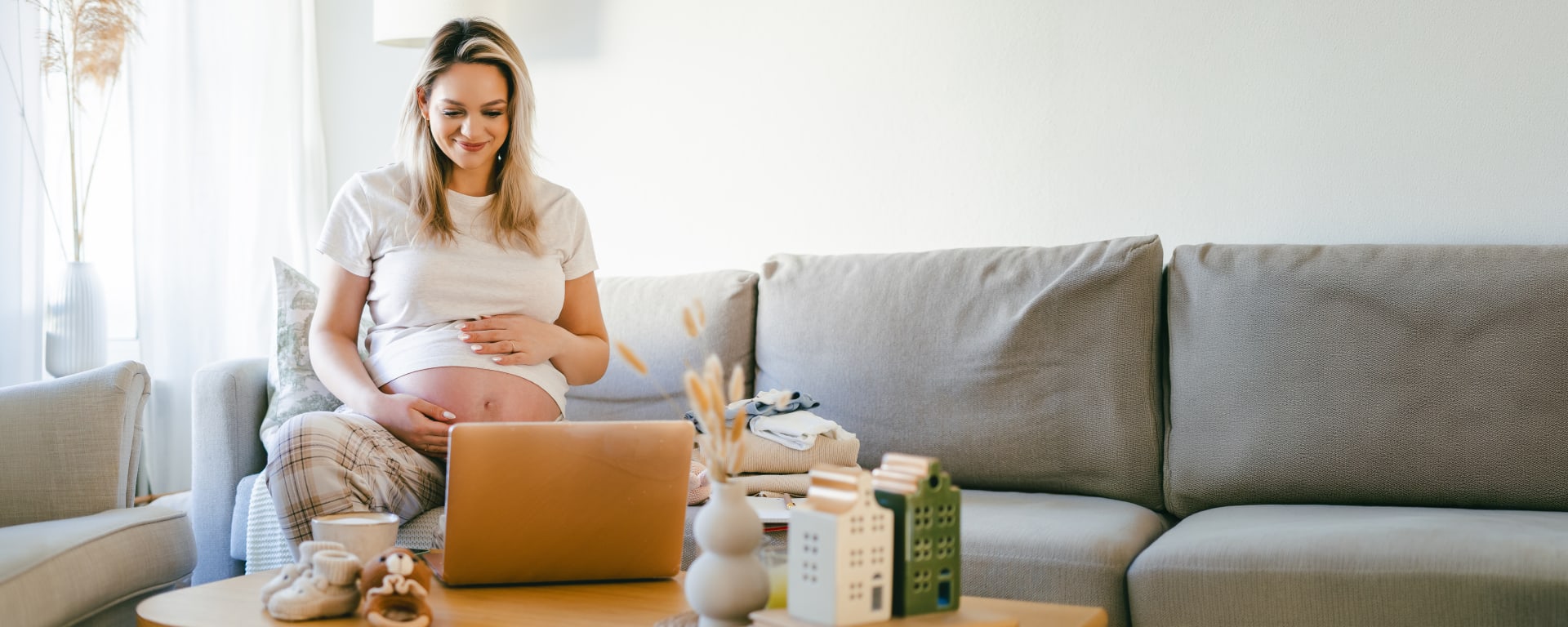 pregnant woman sitting on a couch in her brightly lit home