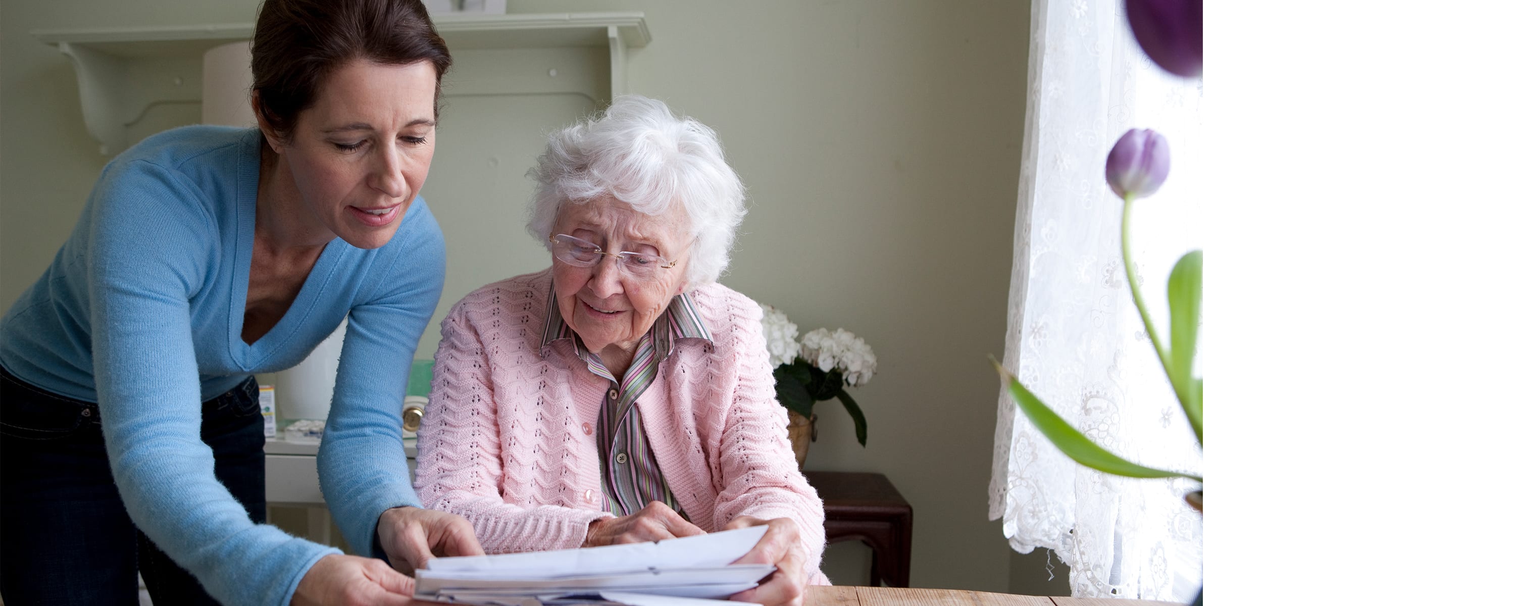 woman looking over paperwork with an elderly woman 