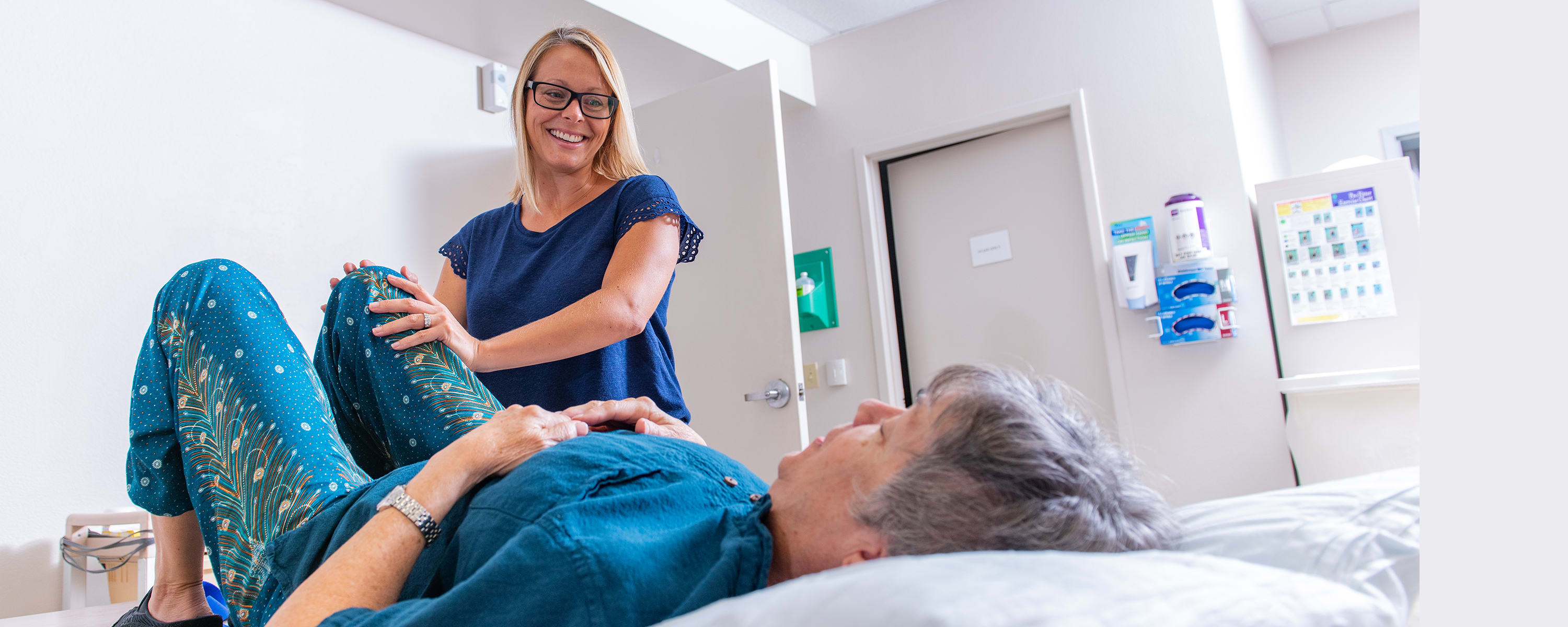 woman working with a rehab patient in an exam room