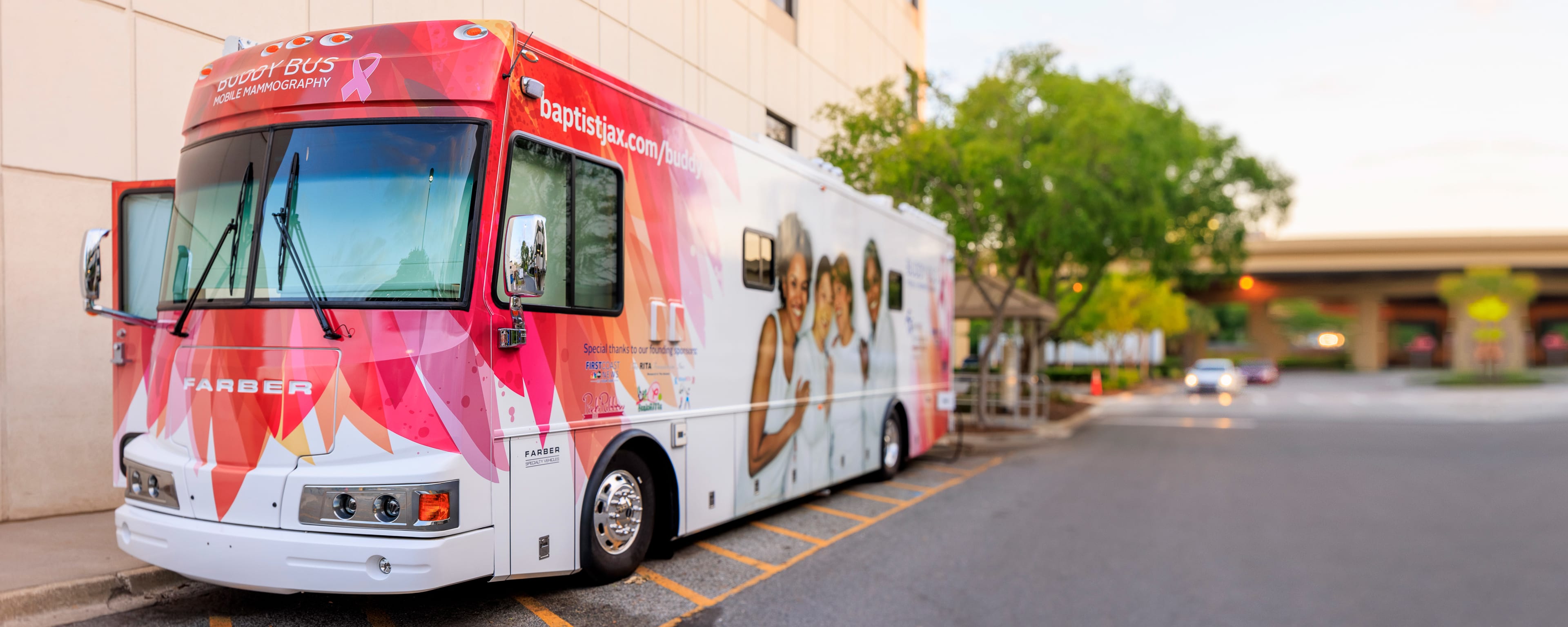 mobile mammography bus (buddy bus) parked outside of a building in bright sunlight