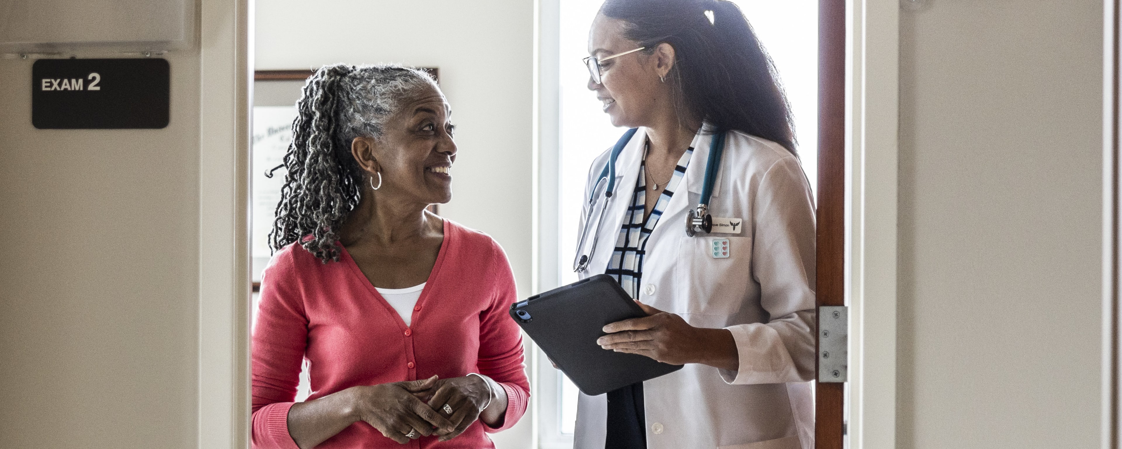 a female doctor talking to a female patient who is smiling