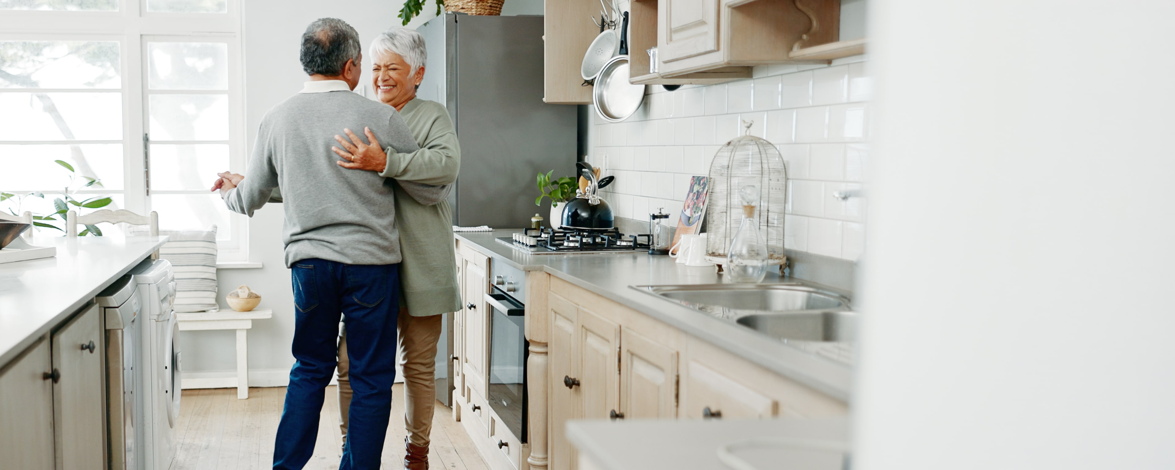Couple dancing in kitchen and smiling