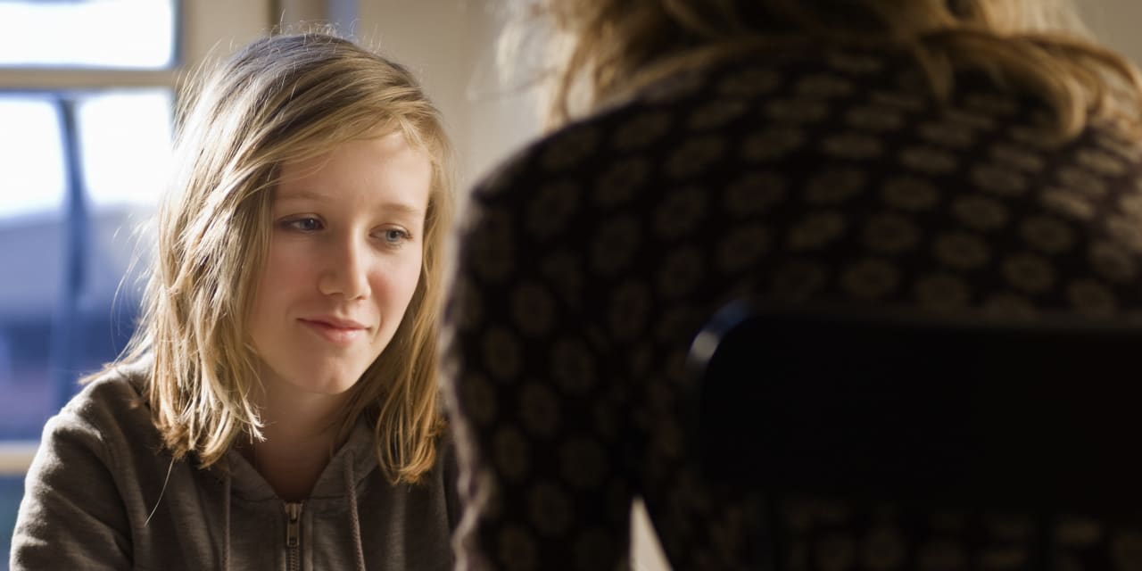 Photo of a teenage girl talking to a counselor